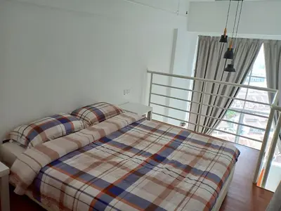 a bedroom with a bed with a plaid blanket at On Cloud 9 @ CEO by Joal in Bayan Lepas