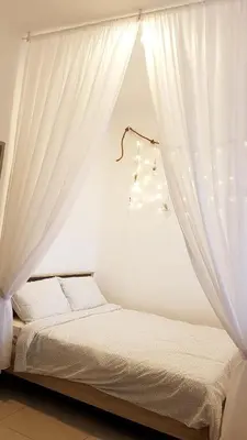 a bedroom with a bed with white curtains at Penthouse - Secret Garden de Cameron, Night Market in Tanah Rata