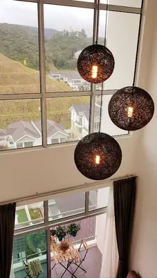 a room with three lights hanging from a large window at Penthouse - Secret Garden de Cameron, Night Market in Tanah Rata