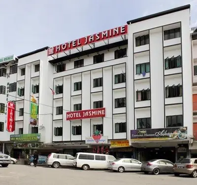 a large white building with cars parked in front of it at Jasmine Hotel in Cameron Highlands