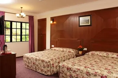 a hotel room with two beds and a window at Jasmine Hotel in Cameron Highlands