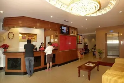 two people standing at a bar in a restaurant at Jasmine Hotel in Cameron Highlands