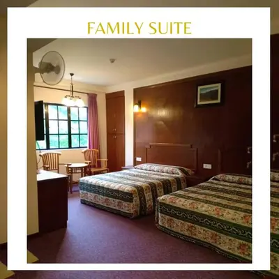 a hotel room with two beds and a table at Jasmine Hotel in Cameron Highlands
