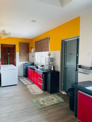 a kitchen with red and yellow walls and a black refrigerator at D Corner Islam Homestay in Kuala Kangsar