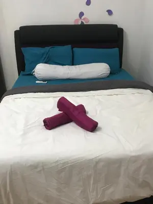 a red towel laying on top of a bed at Seri Manjung Homestay Wazer Residence in Lumut