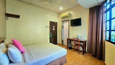 a bedroom with a bed and a desk with a computer at Hotel 22 Gurney, Penang in George Town