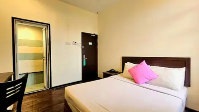 a bedroom with a bed with a pink pillow at Hotel 22 Gurney, Penang in George Town