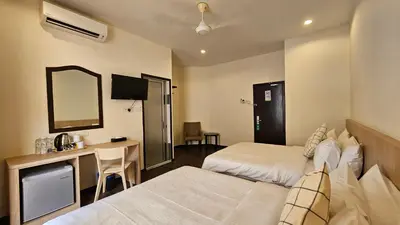 a hotel room with two beds and a desk and a mirror at Hotel 22 Gurney, Penang in George Town