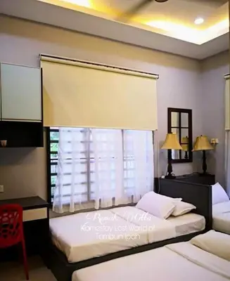 two twin beds in a bedroom with a window at Rumah Citta Homestay Tambun Ipoh in Ipoh