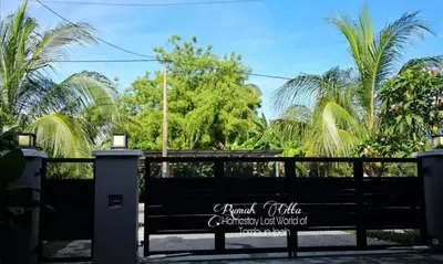 a park bench in front of a fence with palm trees at Rumah Citta Homestay Tambun Ipoh in Ipoh