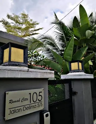 a building with a sign on it with a palm tree at Rumah Citta Homestay Tambun Ipoh in Ipoh