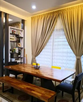 a dining room with a wooden table and a window at Rumah Citta Homestay Tambun Ipoh in Ipoh