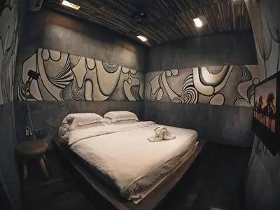 a bed in a room with a painting on the wall at The Happy 8 Retreat in Ipoh