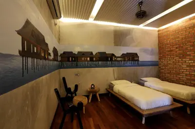 a room with two beds and a brick wall at The Happy 8 Retreat in Ipoh