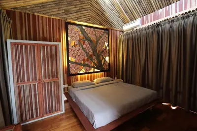 a bedroom with a bed and a tree mural at The Happy 8 Retreat in Ipoh