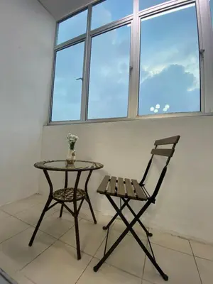 a table and a chair in a room with a window at SYA HONEY HOMESTAY with NETFLIX in Cameron Highlands