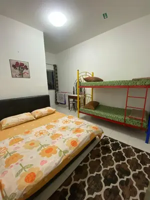 a bedroom with a bed and bunk beds with a rug at SYA HONEY HOMESTAY with NETFLIX in Cameron Highlands