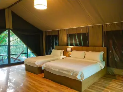 a bedroom with two beds and a large window at Boulder Valley in Batu Ferringhi