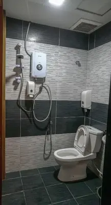 a bathroom with a toilet and a shower at Highlanders Hotel in Cameron Highlands