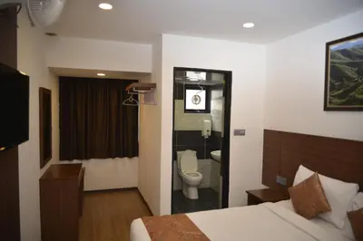 a bedroom with a bed and a toilet in a bathroom at Highlanders Hotel in Cameron Highlands