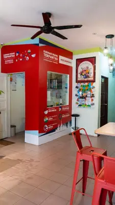 a store with a red wall and a red chair at Highlanders Hotel in Cameron Highlands