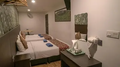 a hotel room with two beds and a hair dryer at Highlanders Hotel in Cameron Highlands