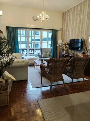 a living room with a couch and a table and chairs at Cameron Greenhill Apartment in Cameron Highlands