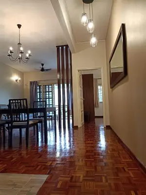 a dining room and living room with a wooden floor at Cameron Greenhill Apartment in Cameron Highlands