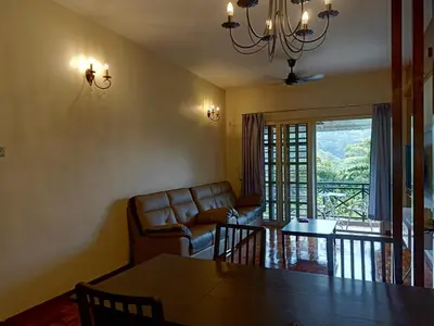 a living room with a couch and a table at Cameron Greenhill Apartment in Cameron Highlands