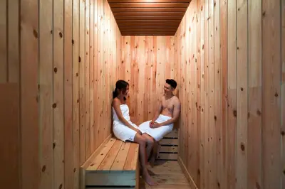 a man and woman sitting in a sauna at Hompton Hotel by the Beach in George Town