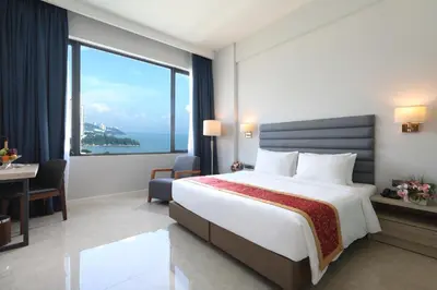 a hotel room with a bed and a large window at Hompton Hotel by the Beach in George Town