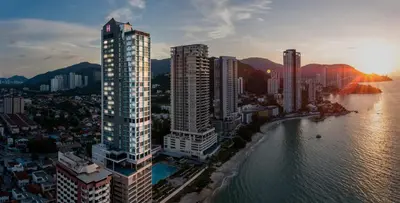 a city with tall buildings next to the water at Hompton Hotel by the Beach in George Town