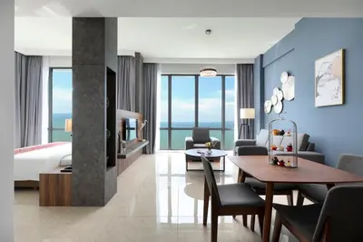 a hotel room with a bed and a dining room at Hompton Hotel by the Beach in George Town