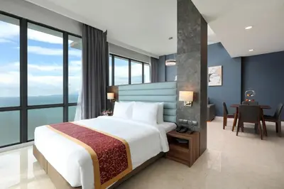 a bedroom with a large bed and a desk with a tableablish at Hompton Hotel by the Beach in George Town