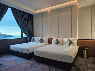 a hotel room with two beds and a large window at Hompton Hotel by the Beach in George Town