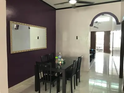 a dining room with a table and chairs and a mirror at Safwa Homestay Bagan Serai in Bagan Serai