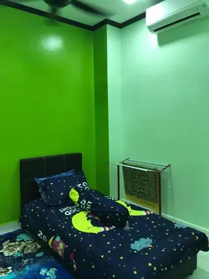 a bedroom with a bed with a green wall at Safwa Homestay Bagan Serai in Bagan Serai