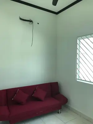 a red couch in a white room with a window at Safwa Homestay Bagan Serai in Bagan Serai