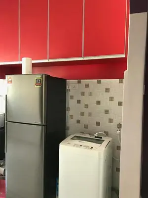 a kitchen with a white refrigerator and red cabinets at Safwa Homestay Bagan Serai in Bagan Serai