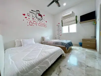 a bedroom with two beds and a ceiling fan at Ks Homestay in Taiping