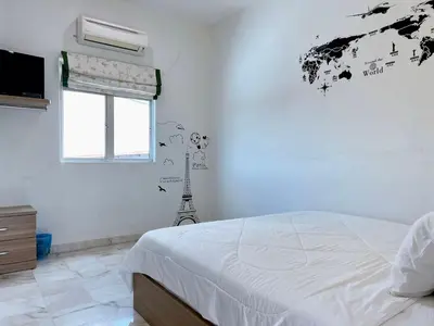 a bedroom with a bed and a television and a window at Ks Homestay in Taiping