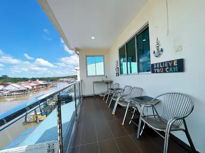 a balcony with chairs and a table and a view of the water at Ks Homestay in Taiping