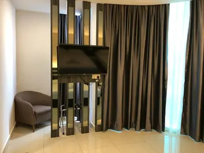 a living room with a tv and a chair and curtains at KU-3 HOTEL in Tapah