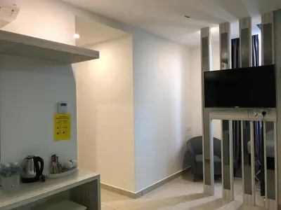 a living room with a flat screen tv on a wall at KU-3 HOTEL in Tapah