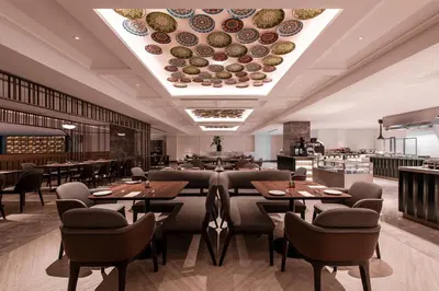 a restaurant with tables and chairs and plates on the ceiling at Ascott Gurney Penang in George Town
