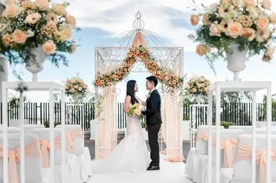 a bride and groom standing in front of a wedding arch at Ascott Gurney Penang in George Town