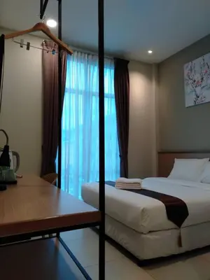 a bedroom with a bed and a desk and a window at MD Boutique Hotel in Kampar