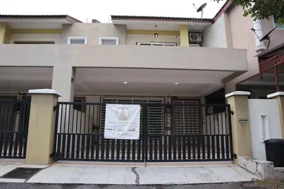 a building with a gate with a sign on it at Dudu Guesthouse Kuala Kangsar in Kuala Kangsar