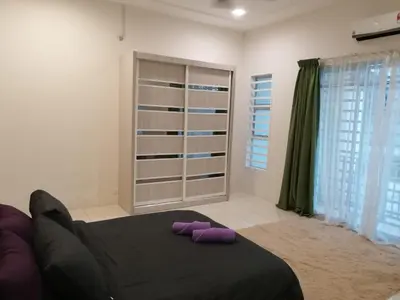 a bedroom with a bed with purple pillows on it at Dudu Guesthouse Kuala Kangsar in Kuala Kangsar