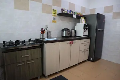 a kitchen with a stove and a refrigerator at Dudu Guesthouse Kuala Kangsar in Kuala Kangsar